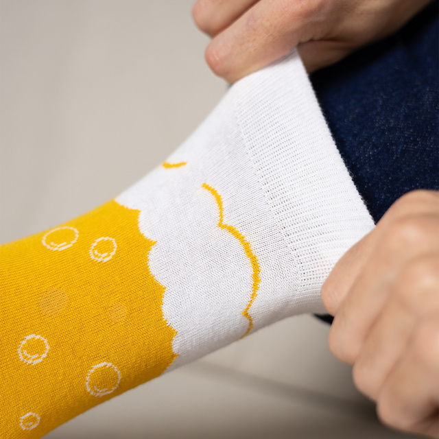 Socken im Bierkrug mit Bierdeckeln
